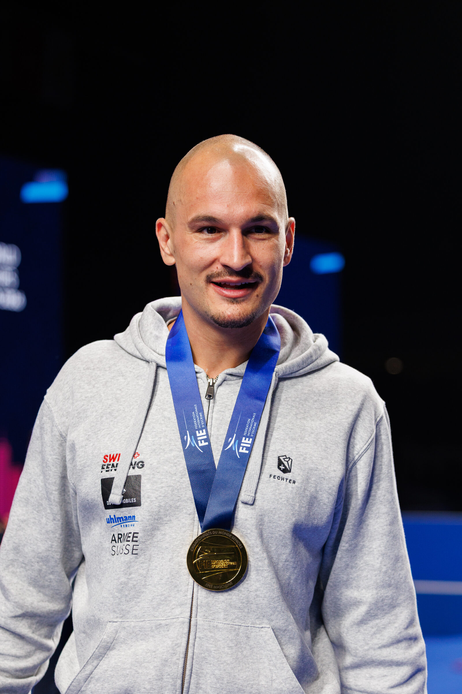 Fencer wearing a gold épée medal after competition