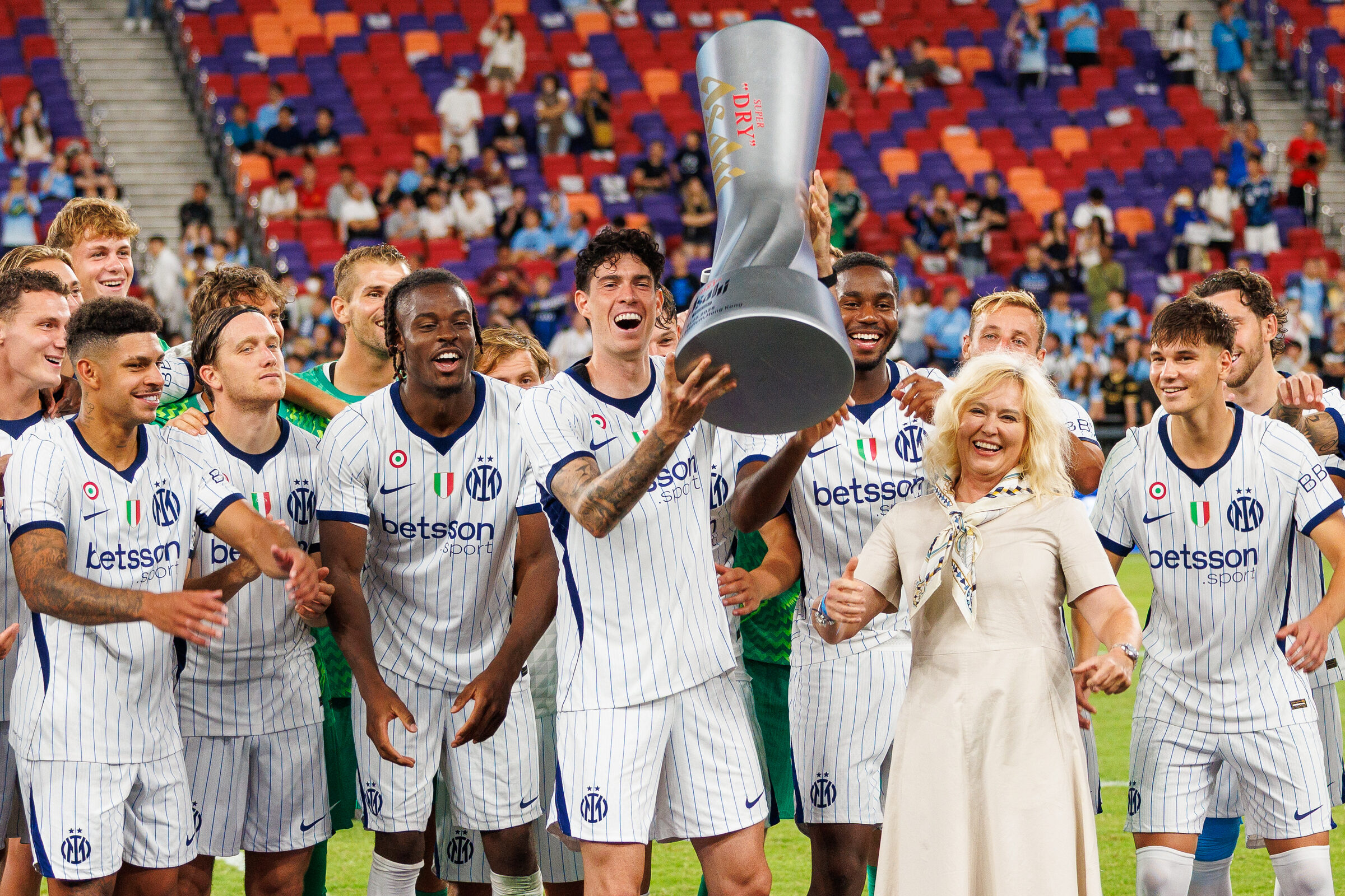 Footballers hoist the Asahi Super Dry trophy on the pitch
